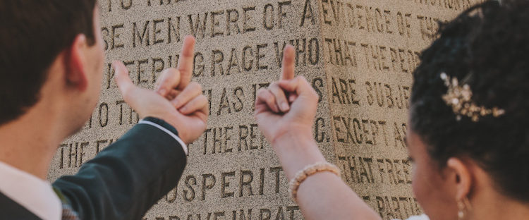 A bride and groom flash their middle fingers at a confederate memorial. Amanda and Steve Say Fuck the Confederacy - Photo by Amanda Summerlin Photgraphy