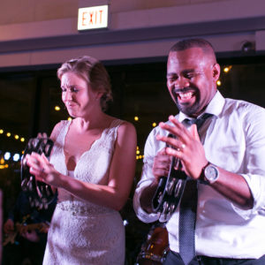 bride and groom play tambourines at wedding reception