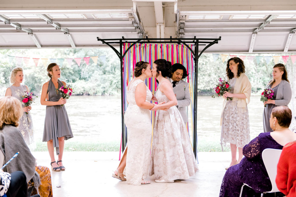 Two brides kiss at end of wedding ceremony