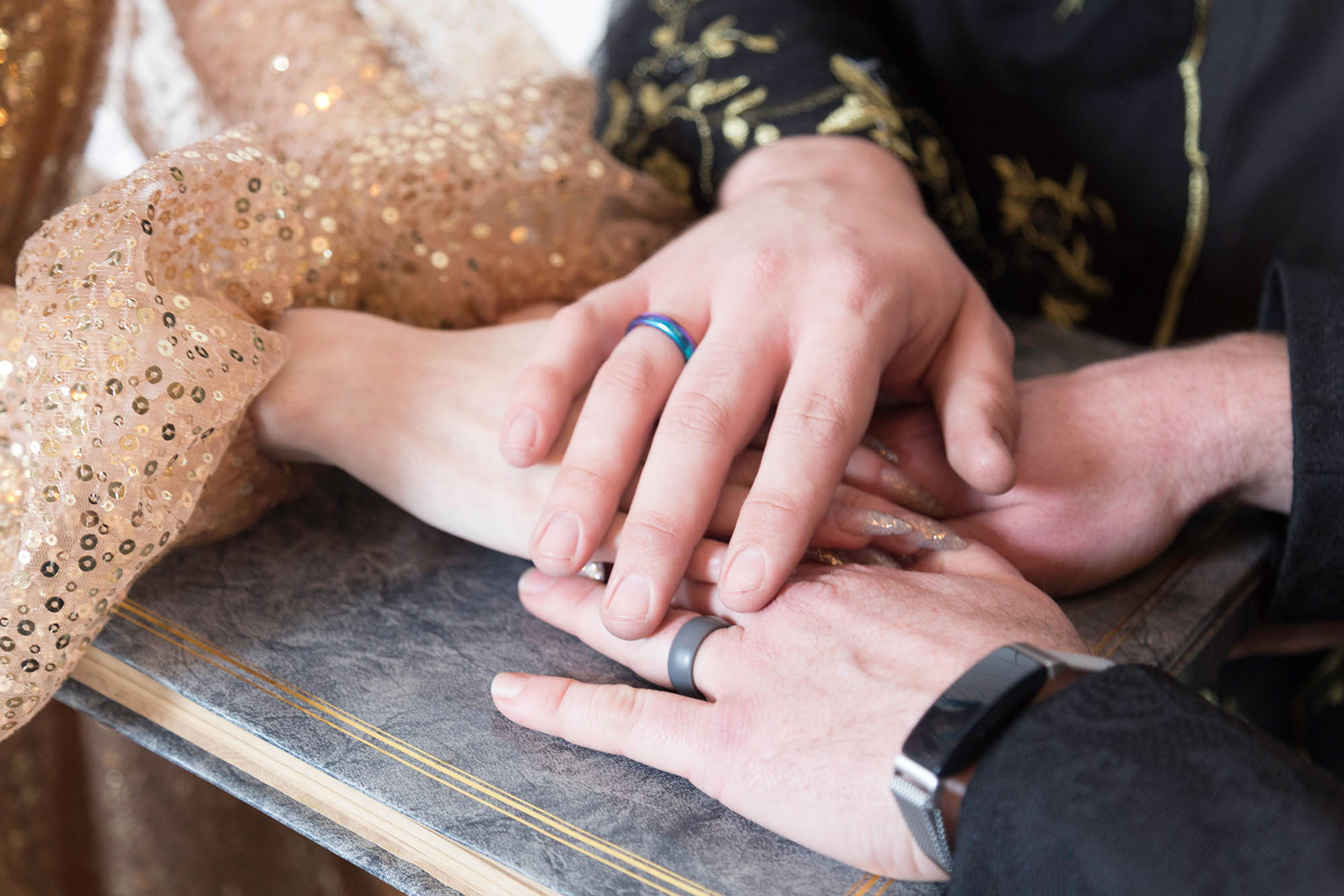 Couple with Hands on Wedding Ceremony Script and Gold Sequin Bridal Gown