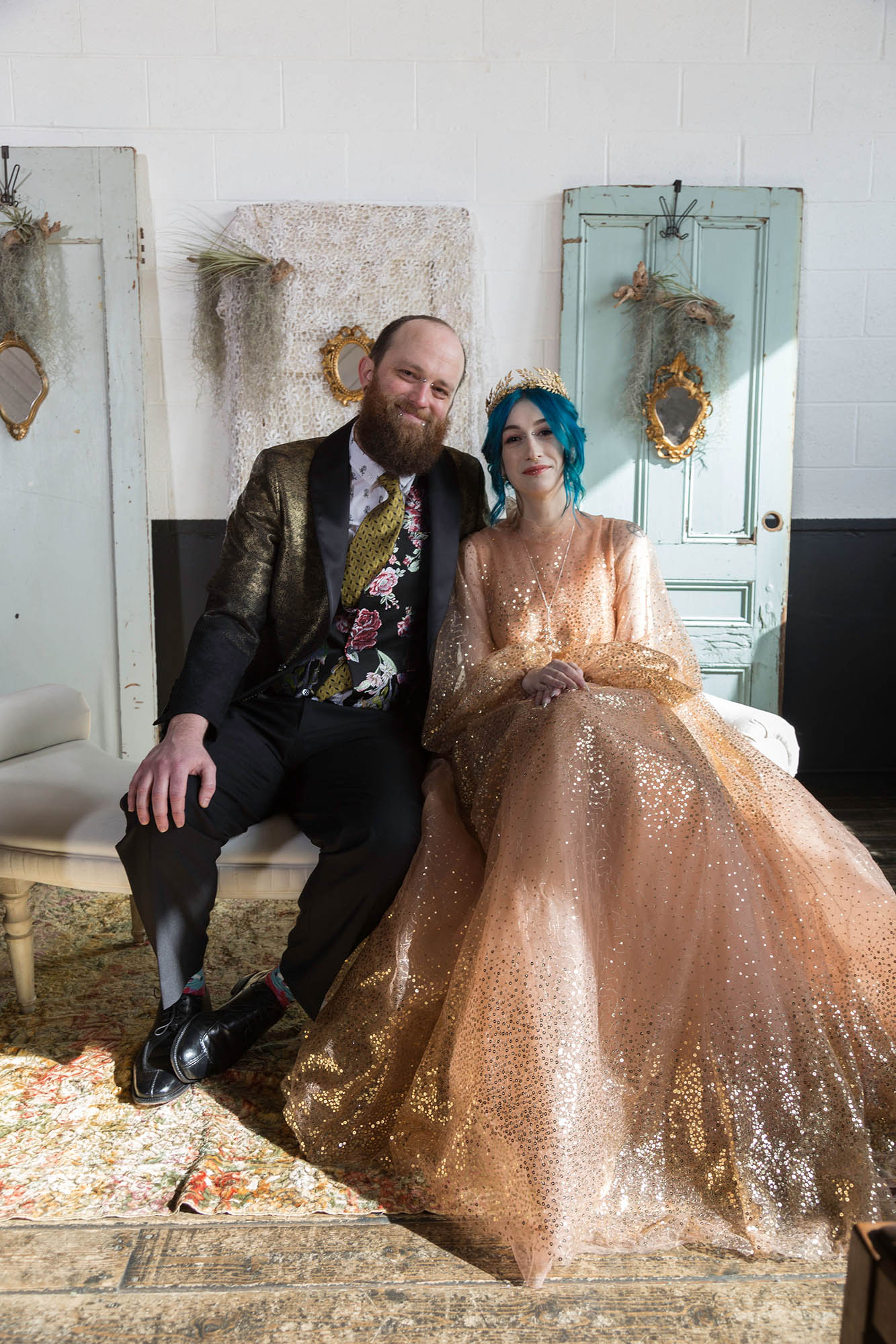 Offbeat Wedding Couple on Bench in front of Vintage Doors and Air Plants