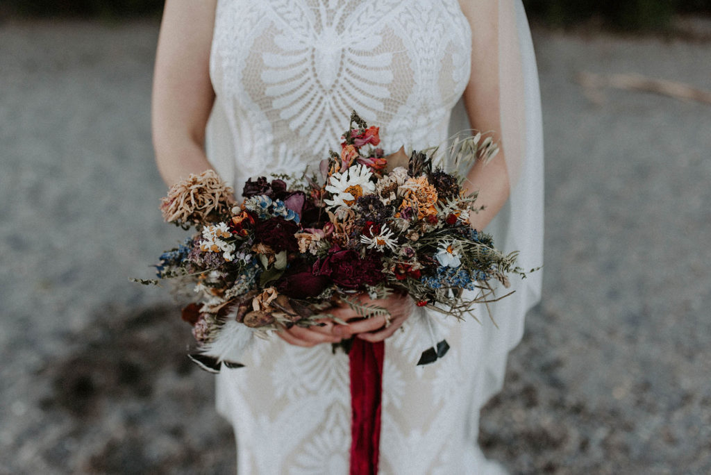 deep saturated hue bridal bouquet with red ribbon