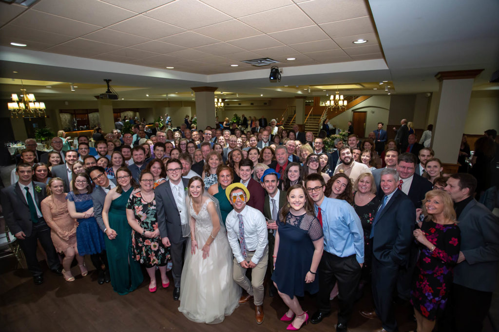 bride and groom with wedding guests group photo at Madison Event Center wedding