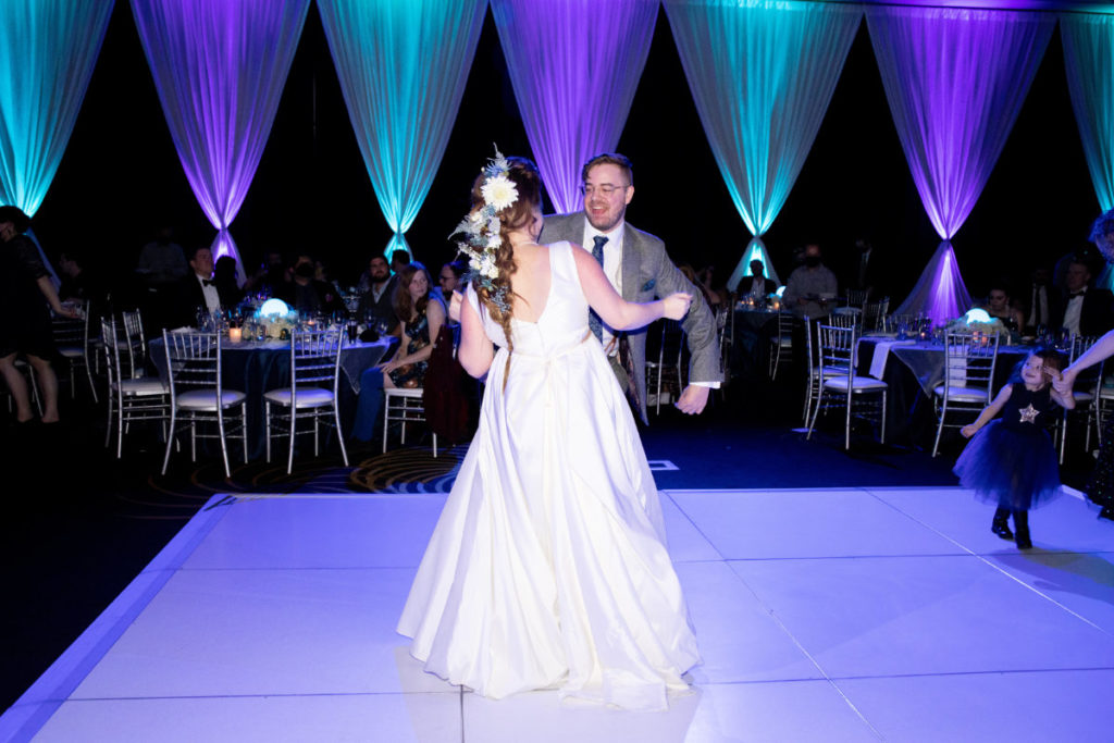bride and groom dancing under blue and purple lights