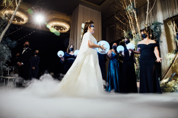 bride enters wedding ceremony holding glowing orb and walking on a cloud fog effect