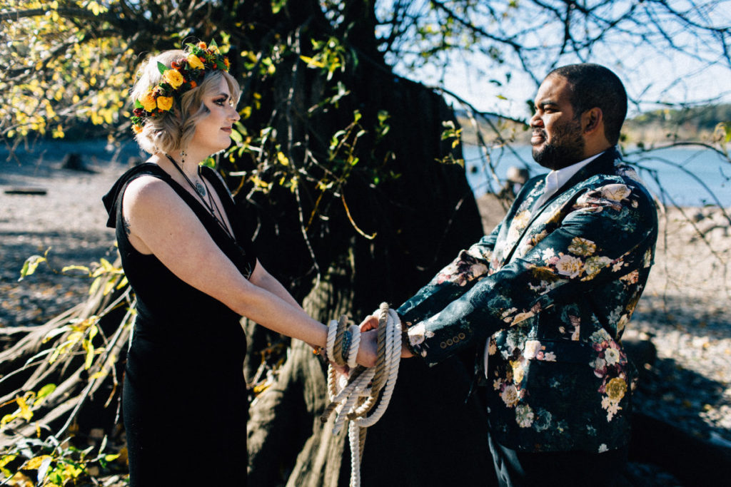 bride in black dress groom in floral blazer handfasting ceremony