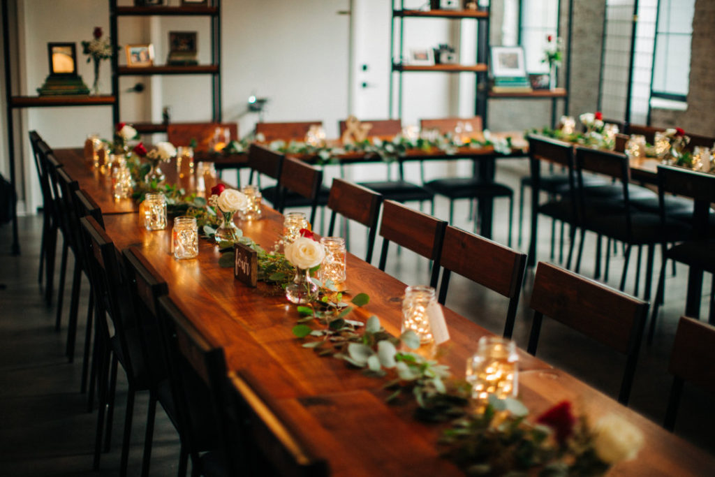 Wood tables with greenery roses and fairy lights