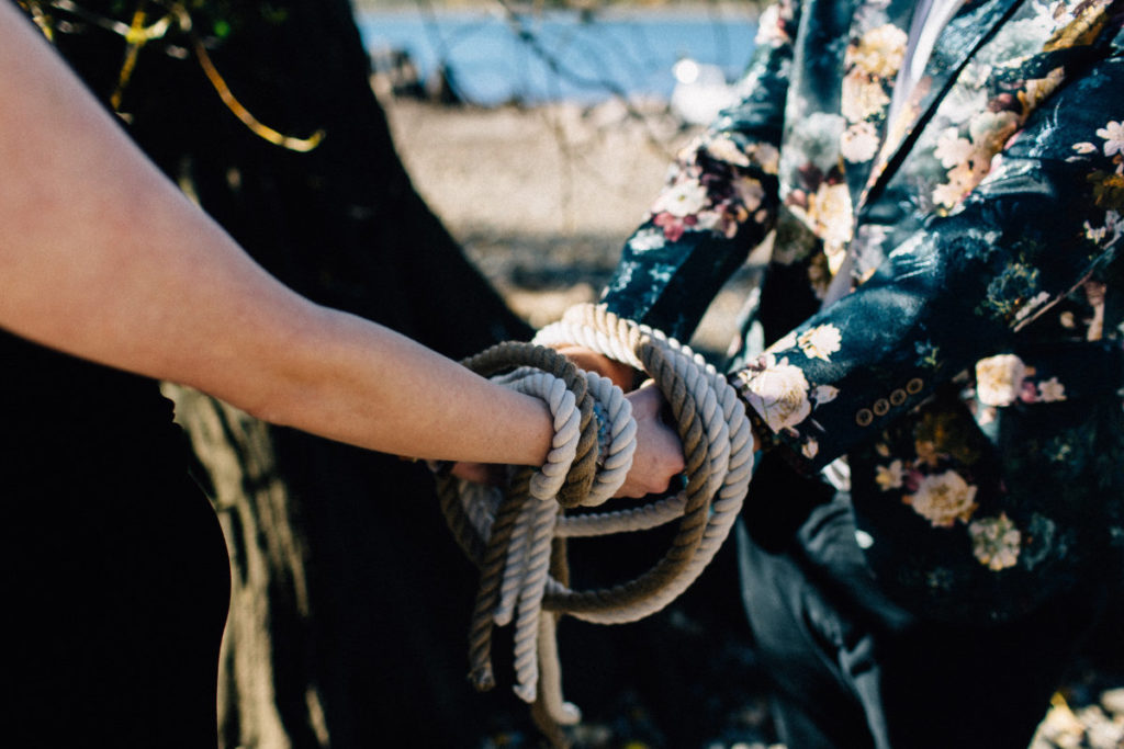 handfasting cords tied around couple during wedding ceremony
