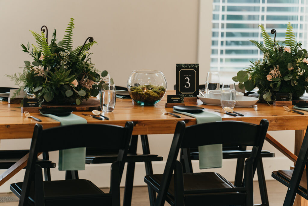 mossy terrarium centerpieces on wood tables with black chairs