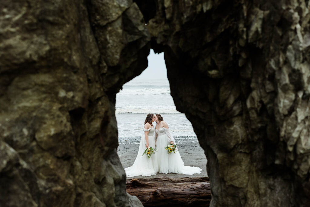 brides kissing on the beach at their wedding in Seattle