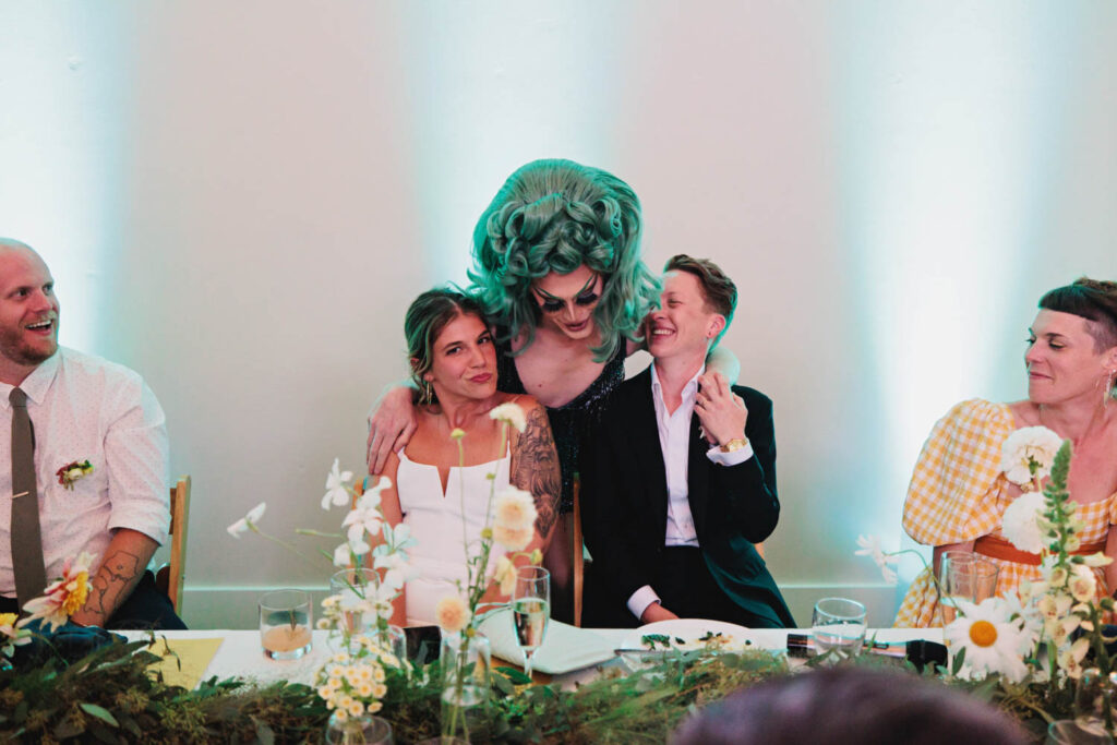 drag queen hugging queer wedding couple