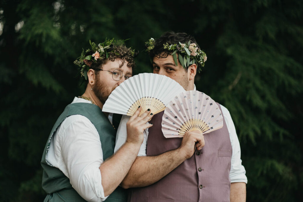 grooms standing together with paper fans