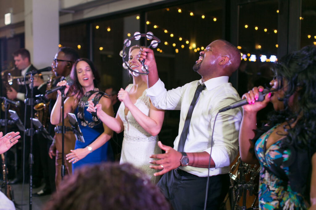 bride and groom performing music with their wedding guests