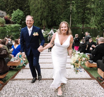 bride and groom walking back down aisle with bubbles floating behind them
