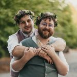 groom with arms around his new husband